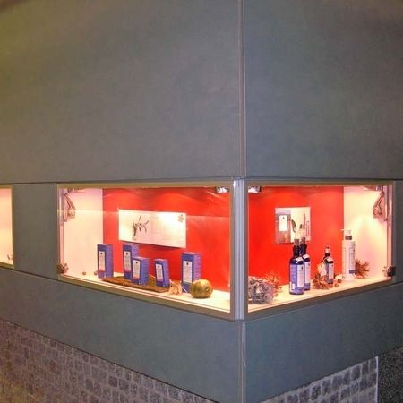 Produktpräsentation an einer Eckwand mit Glasscheiben und rotem Hintergrund
